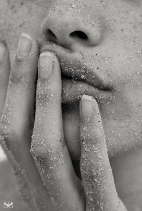 Sand-dusted fingertips resting on lips